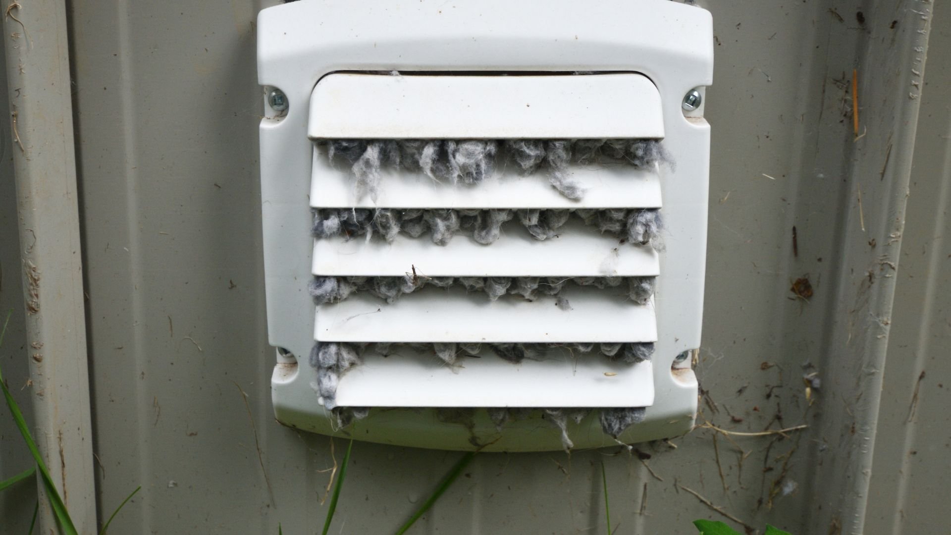 Dryer vent covered in lint and dust, needing urgent cleaning